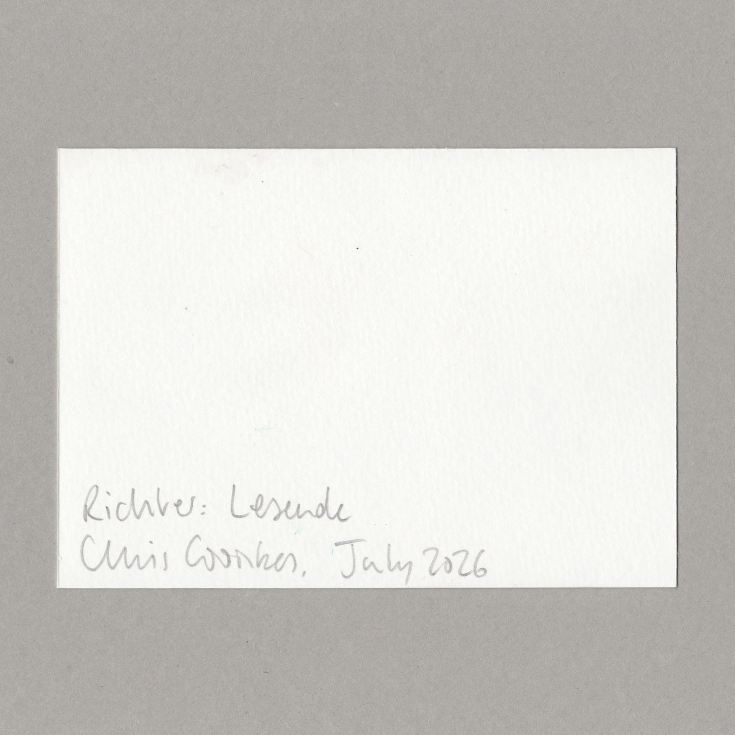 A square white textured paper card with handwritten black ink text in the bottom-left corner, placed on a smooth gray surface. The text reads 'Richter: Lesende' and 'Chris Coombes, July 2026'.