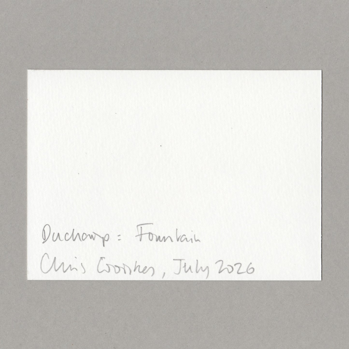 A white card with handwritten text in the lower left corner reading 'Duchamp: Fountain, Chris Coombes, July 2026', centered on a neutral grey background.