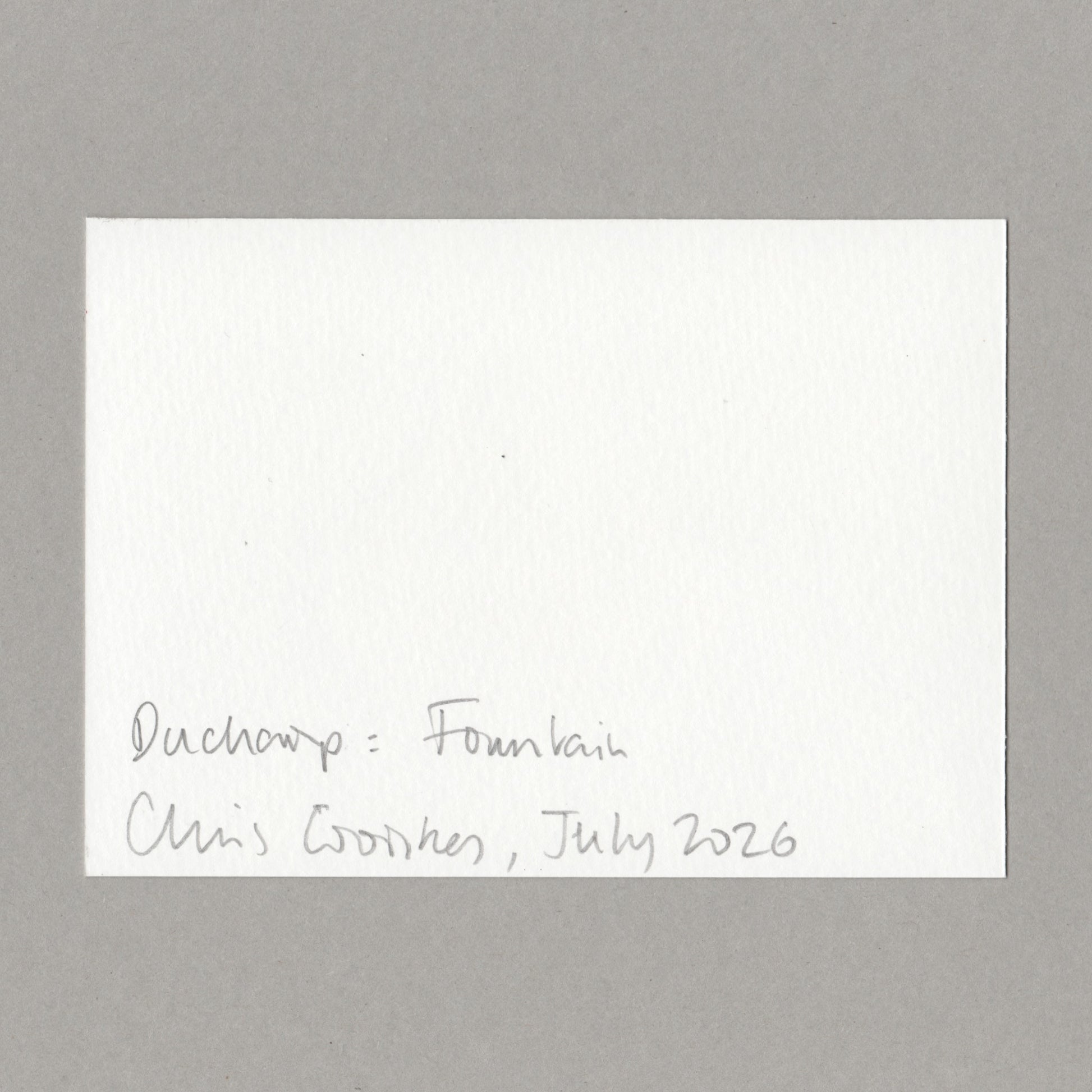 A white card with handwritten text in the lower left corner reading 'Duchamp: Fountain, Chris Coombes, July 2026', centered on a neutral grey background.
