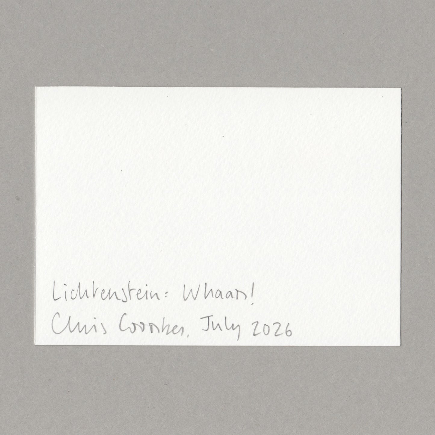 A white card with handwritten text in the lower left corner reading 'Lichtenstein: Whaam! Chris Coombes, July 2026', photographed against a plain grey background.