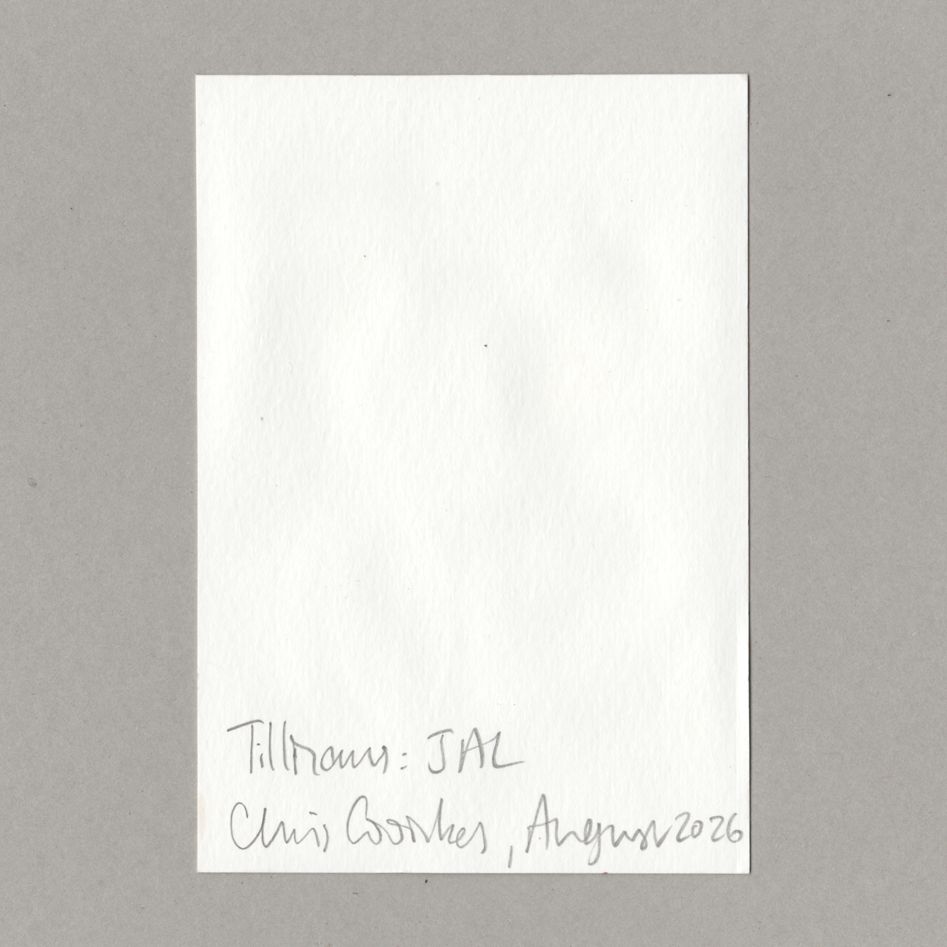 A blank white rectangular card or note with handwritten text at the bottom reading 'Tillmans: JAL Chris Coombes , August 2026', photographed against a plain gray background.