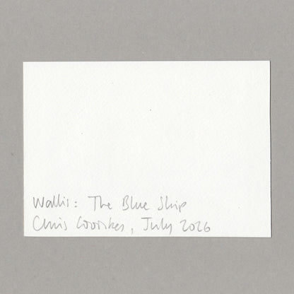 A white rectangular card with handwritten text at the bottom reading 'Walli: The Blue Ship Chris Cowles, July 2026', photographed against a plain gray background.