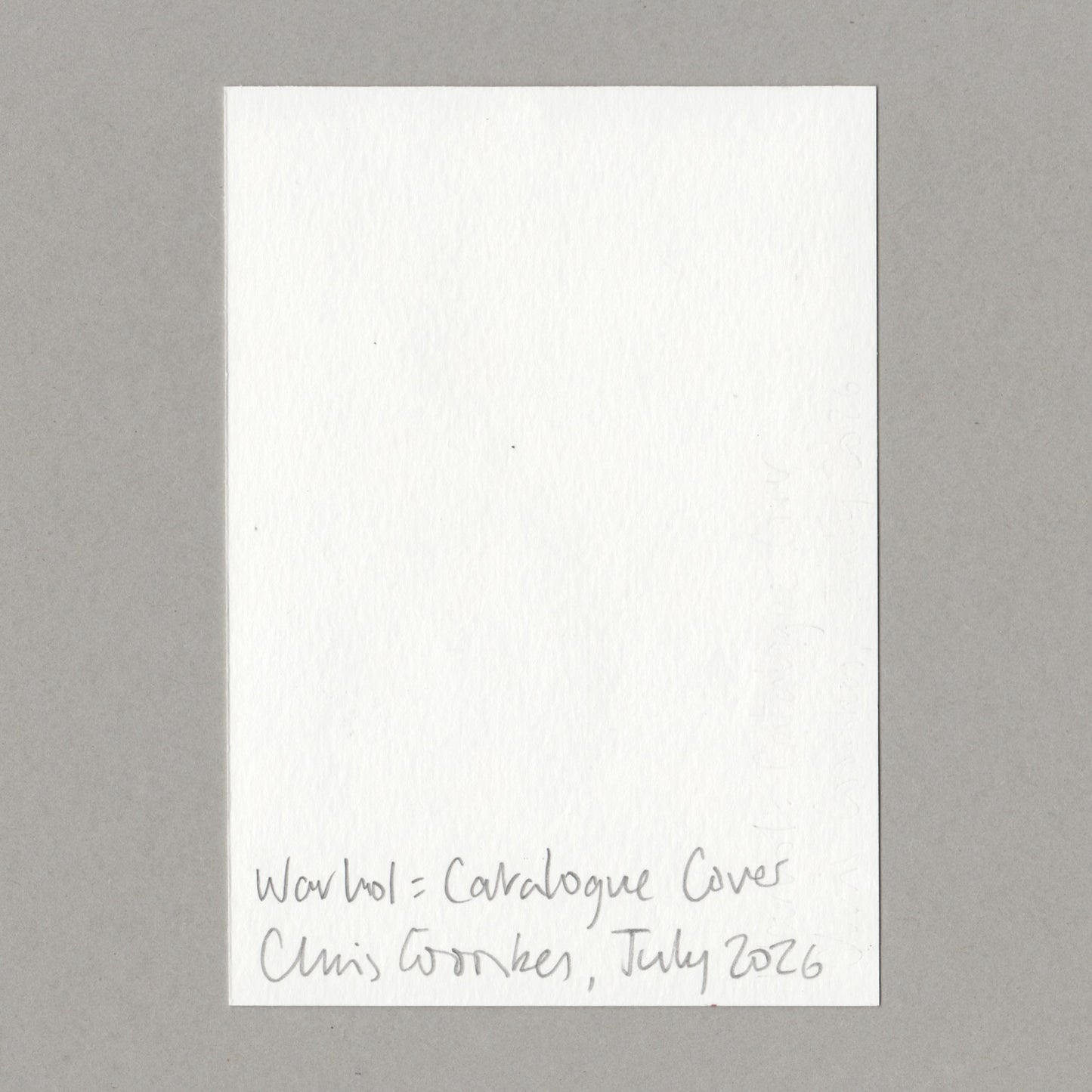 A white textured paper card with handwritten text at the bottom reading 'Warhol  Catalogue Cover Chris Coombes July 2026', centered on a neutral gray background.