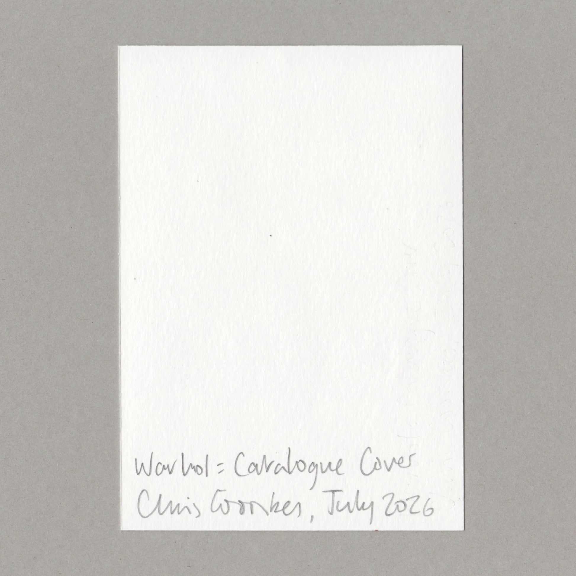 A white textured paper card with handwritten text at the bottom reading 'Warhol  Catalogue Cover Chris Coombes July 2026', centered on a neutral gray background.